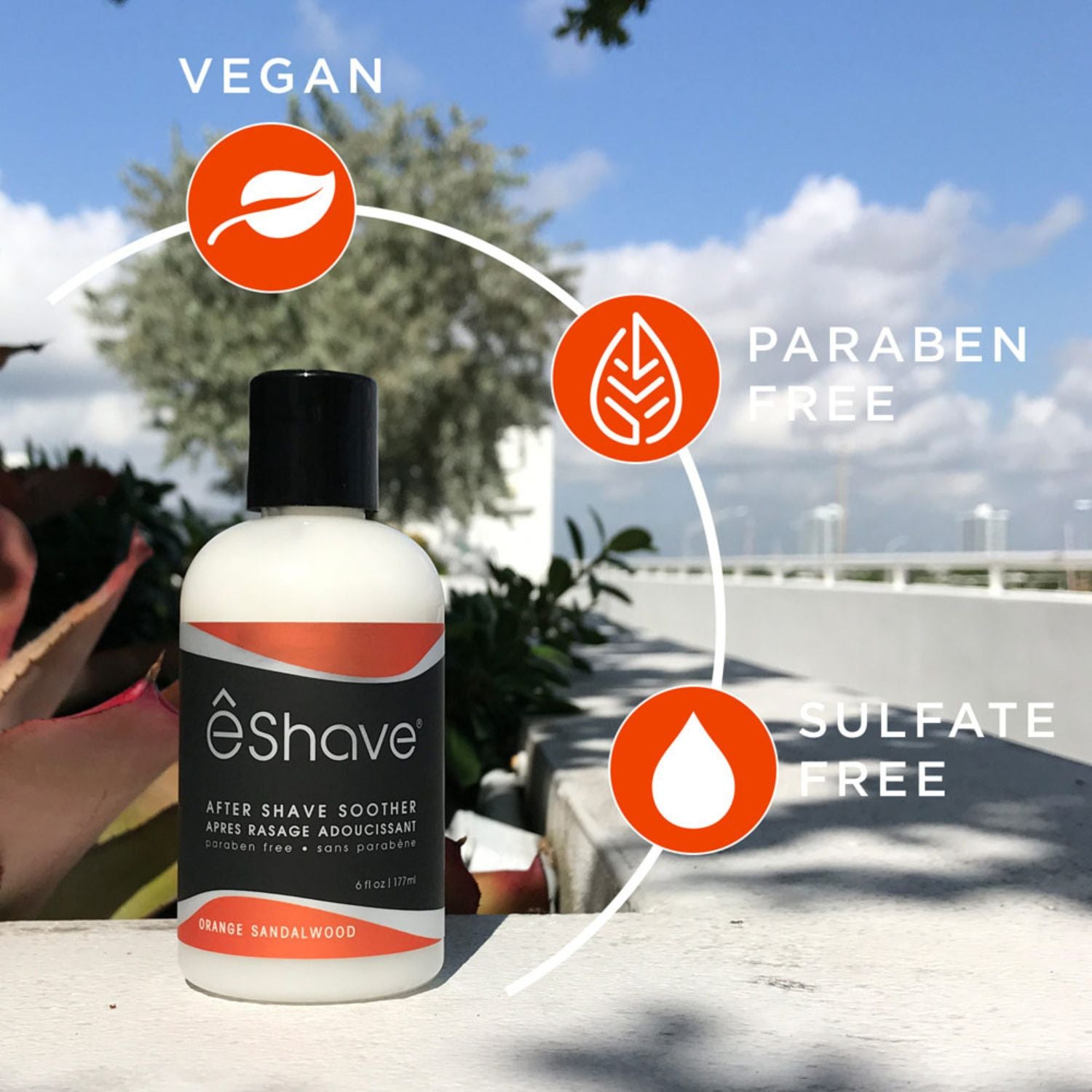 eShave after shave soother bottle with vegan, paraben-free, and sulfate-free icons against a blurred outdoor background.