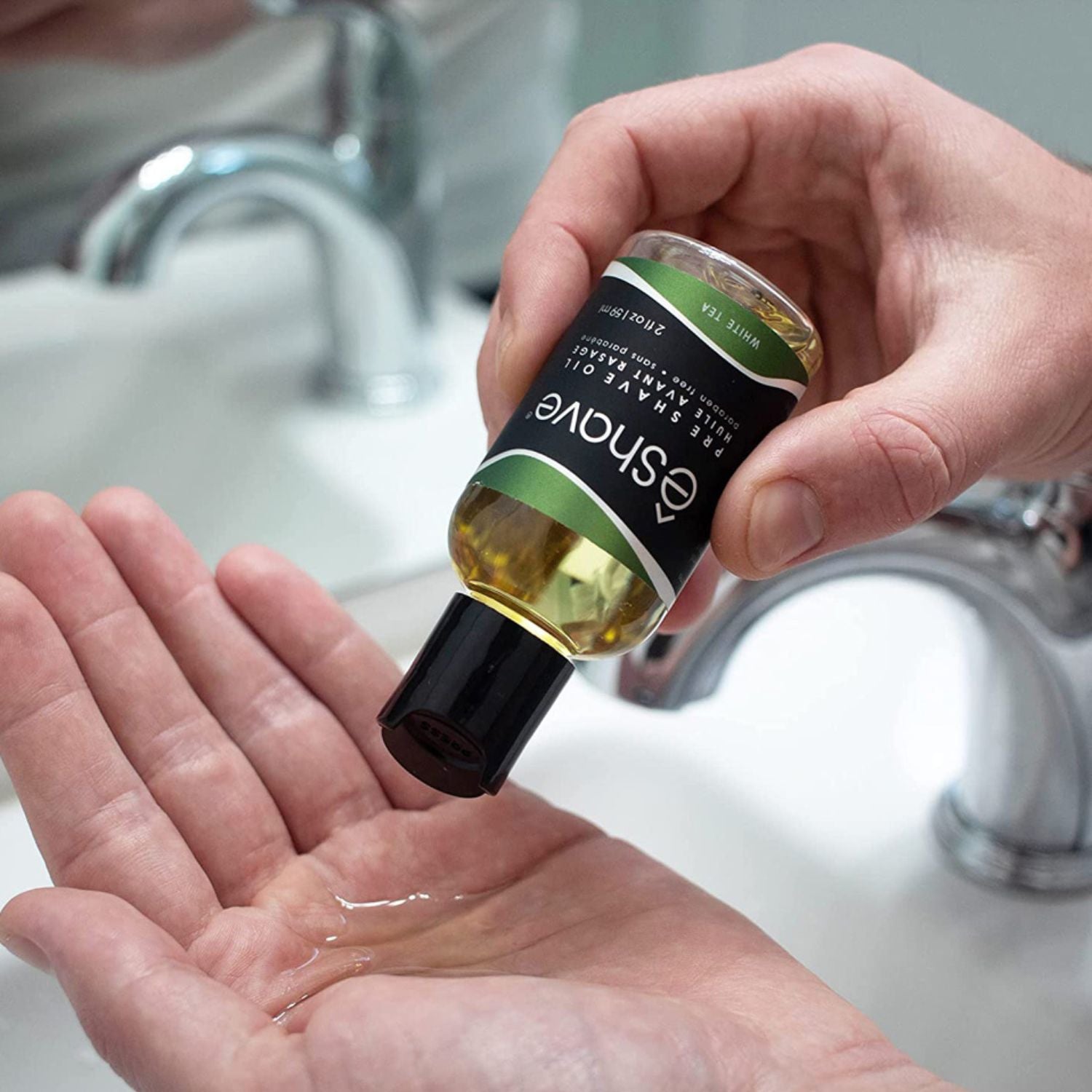 Hand holding a bottle of Shave Company product over a sink.