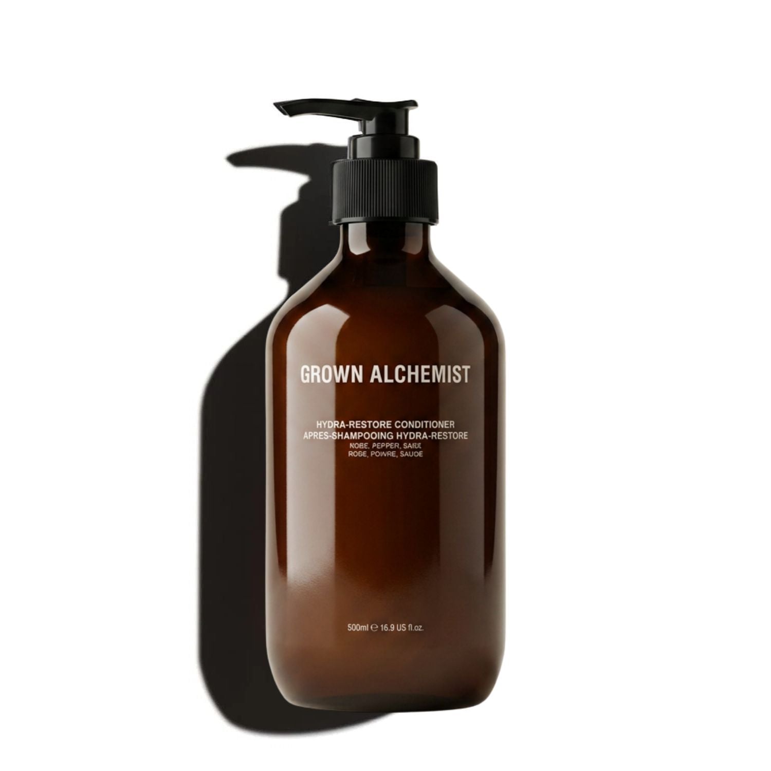 A 500ml amber brown pump bottle of Grown Alchemist Hydra Restore Conditioner, shown on a clean white background with a prominent cast shadow.