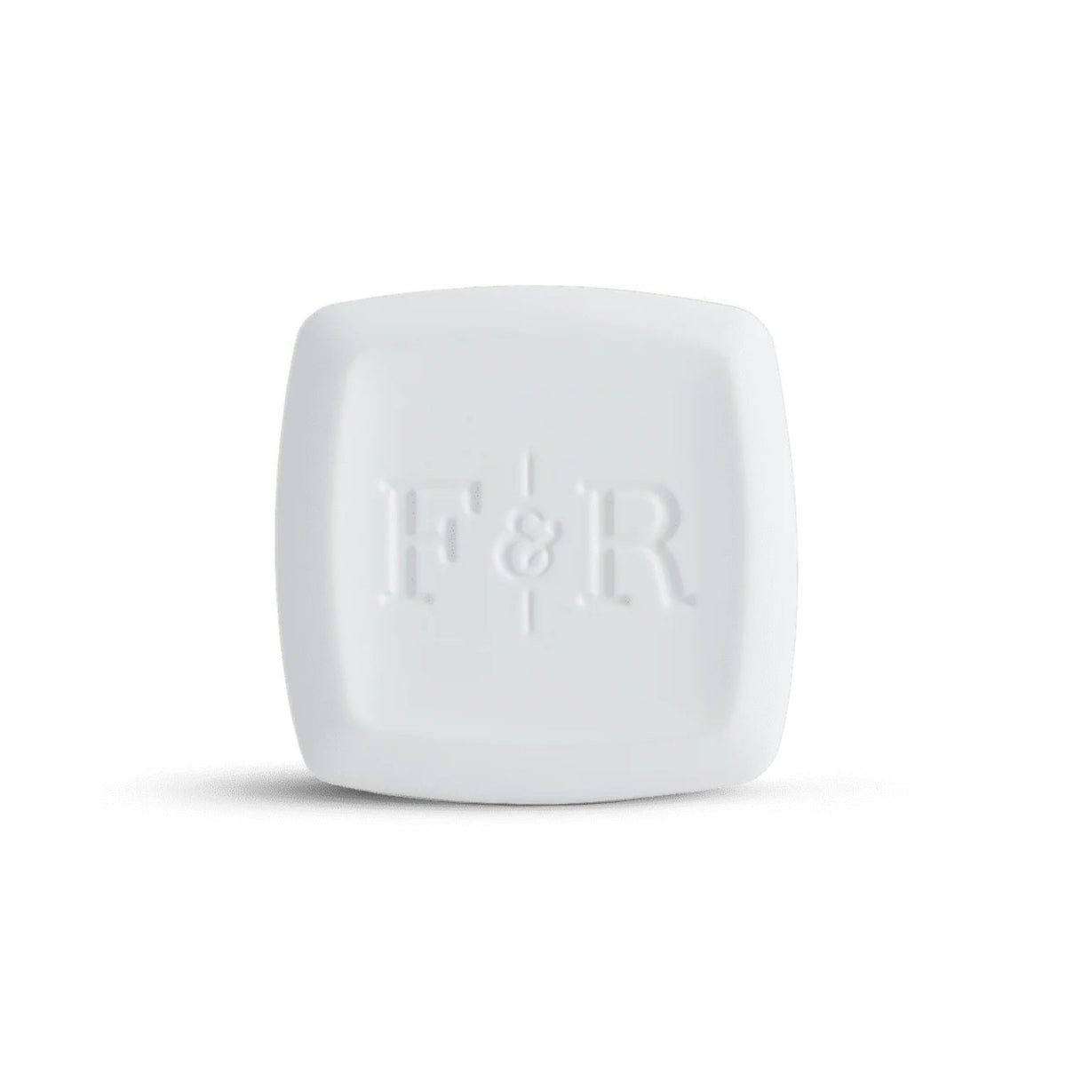 A white square cosmetic compact with rounded corners and a debossed 'F&R' logo on the front, set against a plain white background with a soft shadow.