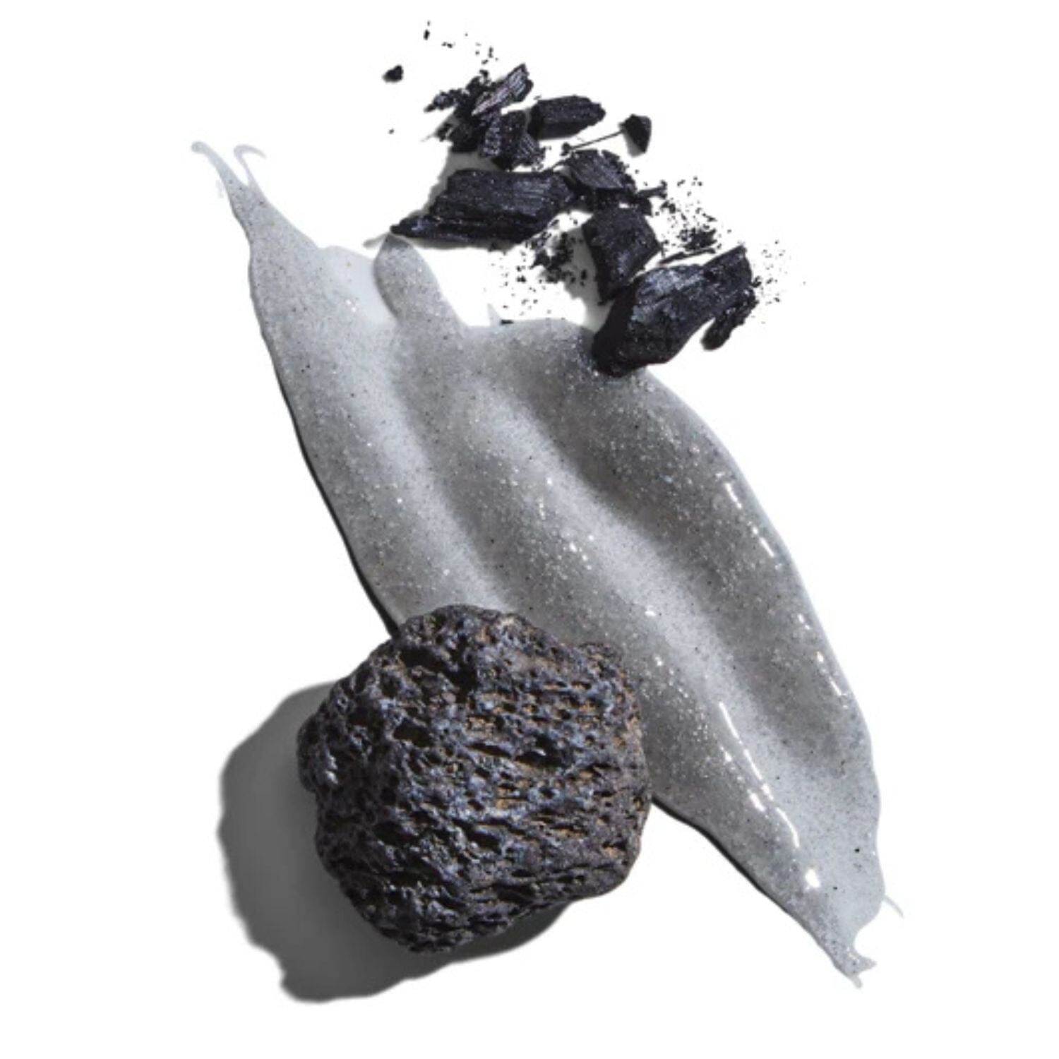 Black volcanic rock with a white creamy substance on a white background