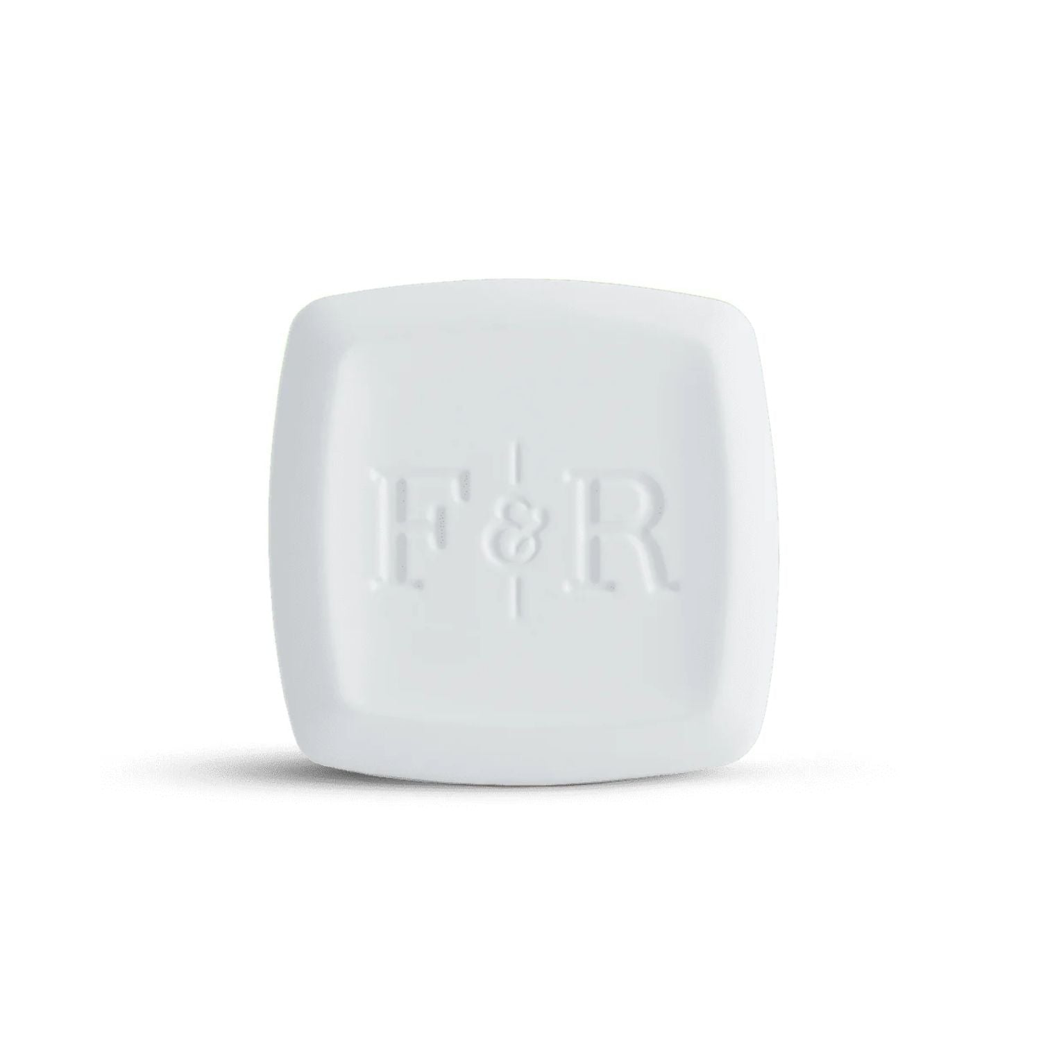 A white square cosmetic compact with rounded corners and a debossed 'F&R' logo on the front, set against a plain white background with a soft shadow.