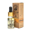 A bottle of beard oil with a black dropper cap and gold collar, shown next to its brown cardboard packaging box on a white background.