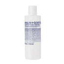 A white plastic bottle of Malin+Goetz Grapefruit Face Cleanser with a white cap, featuring blue text and fine print on the front label, set against a plain white background.