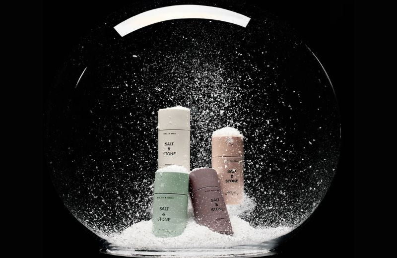 Four Salt & Stone deodorants in a snow globe with a black background