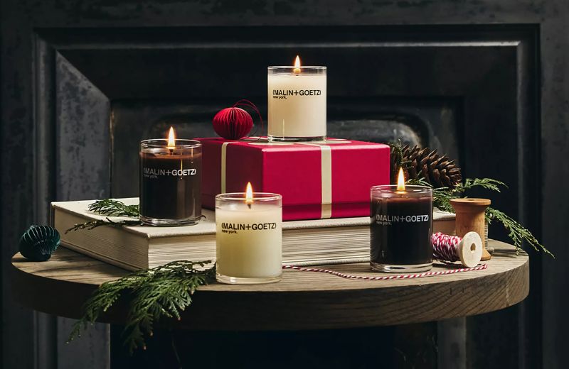 Candles and a gift box on a wooden table with a dark background
