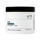 A white plastic jar of Urth Face Scrub with a black lid, shown against a plain white background.
