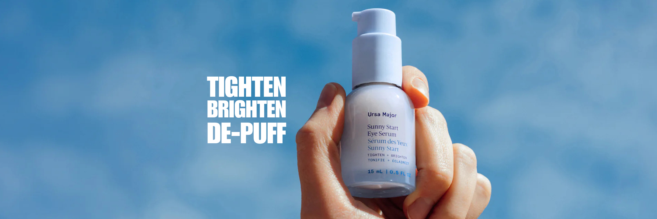Hand holding a skincare bottle with text 'Tighten Brighten De-Puff' against a blue sky.