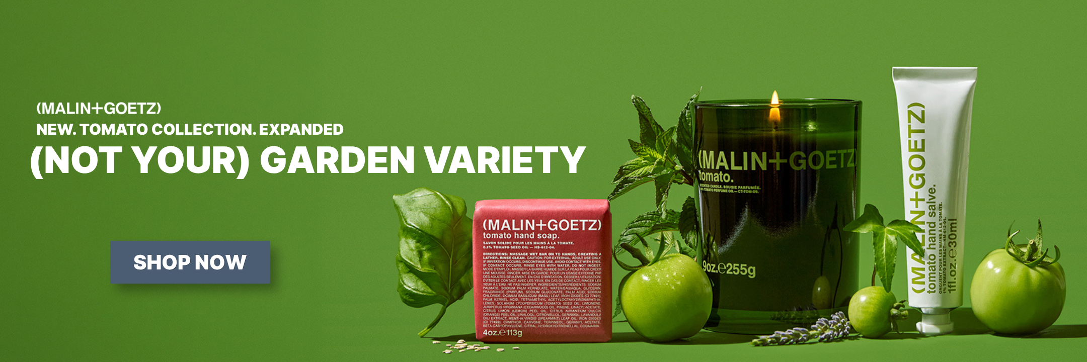 Tomato candle collection from malin and goetz with heading "Not Your Garden Variety" on a green background surrounded by green tomatoes